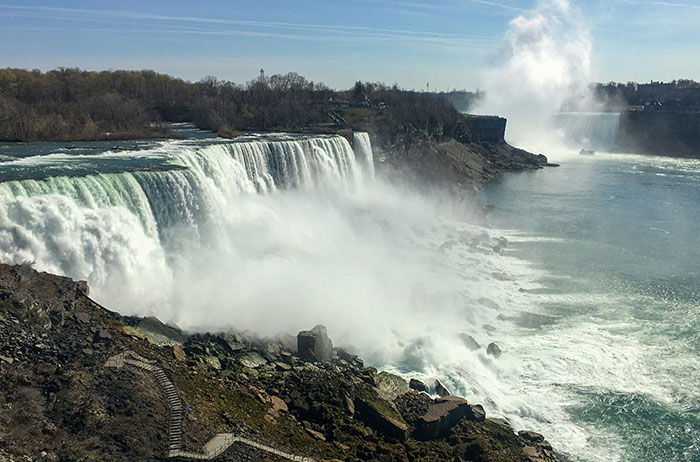 Wide view of a large waterfall with mist rising, illustrating dramatic and unexpected natural scenes related to lives ending unexpectedly.
