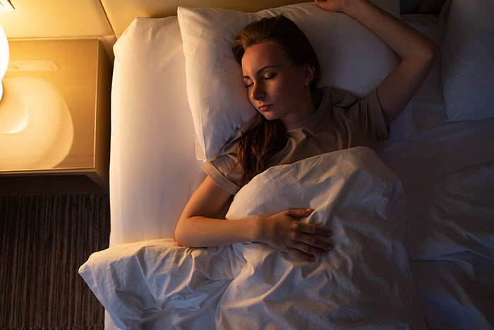 Woman lying in bed at night, eyes closed, illustrating women’s intuition and deep inner awareness.