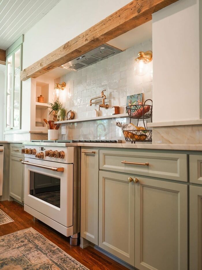 Bright kitchen in a beautiful old house featuring classic cabinetry, brass fixtures, and wooden craftsmanship details.