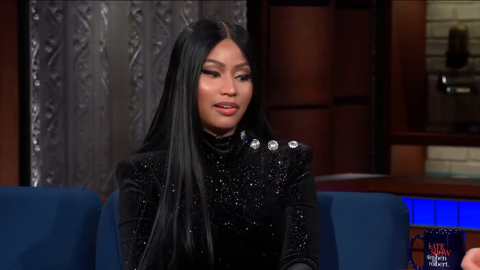 Woman with long black hair and a sparkling black top speaking on a talk show about flight crew passenger horror stories.