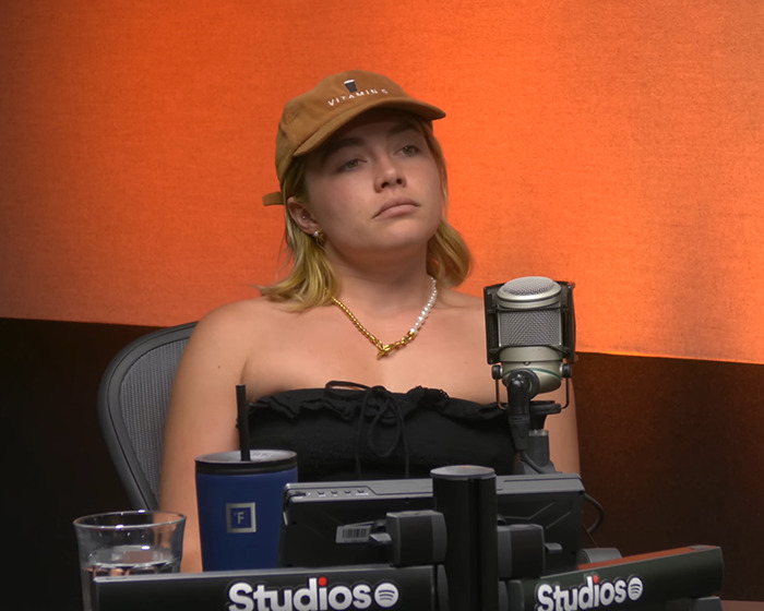 Florence Pugh speaking in a podcast studio about her completely inappropriate experience filming steamy scenes on set.