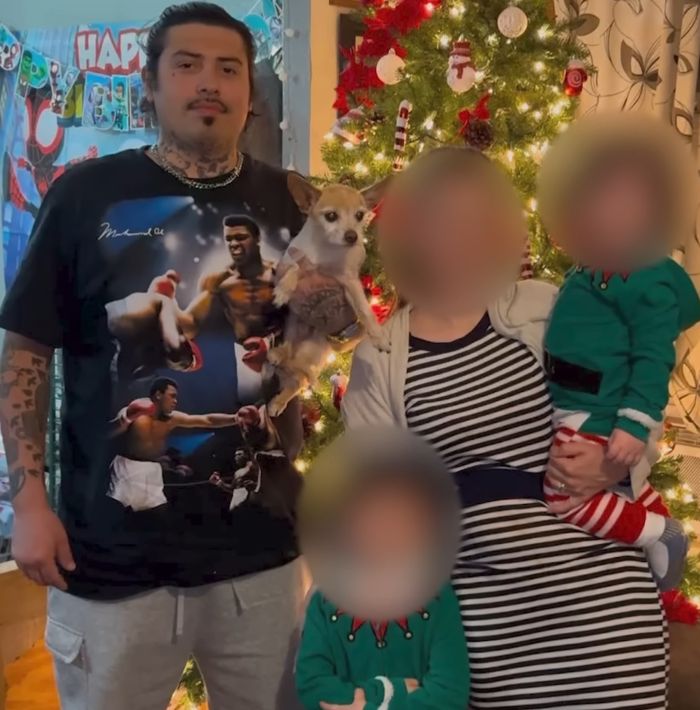 Family standing by decorated Christmas tree with blurred faces, unrelated to woman found chained in backyard SEO keywords.