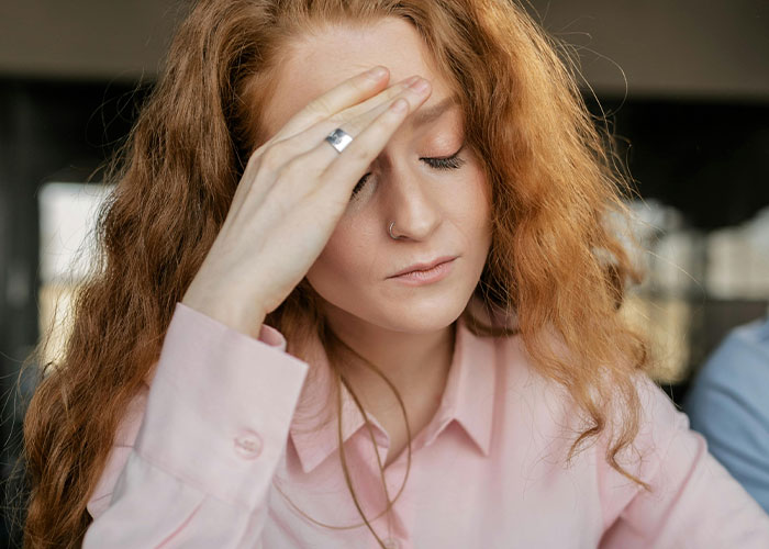 Woman stressed and disappointed at work, reflecting challenges of hospital&rsquo;s family first vacation policy impact on employees.