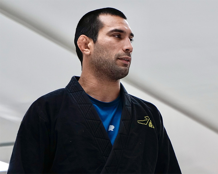 Jiu-Jitsu trainer in black gi looking to the side after tragic freak accident during sparring session