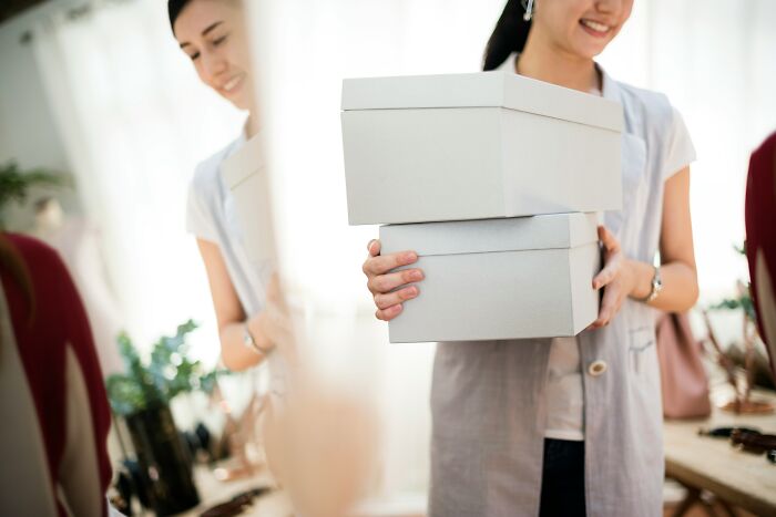 Woman holding two gift boxes, symbolizing a situation involving gifting broken items and a disagreement over it.