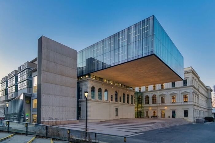 Modern architecture with an unesthetic and depressing building featuring a cantilevered glass and concrete structure.