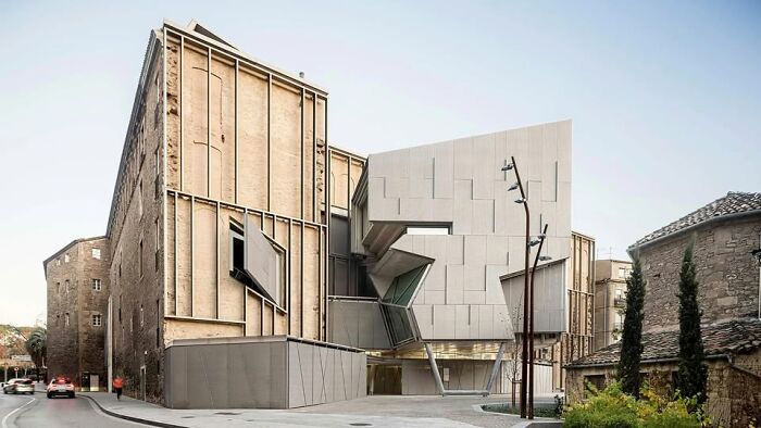 Unesthetic modern architecture building with sharp angles and a dull, beige facade in an urban setting at daylight.