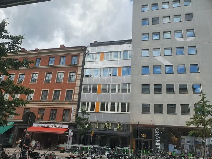 Street view of unesthetic and ugly buildings with dull facades and mismatched architectural styles in an urban setting.