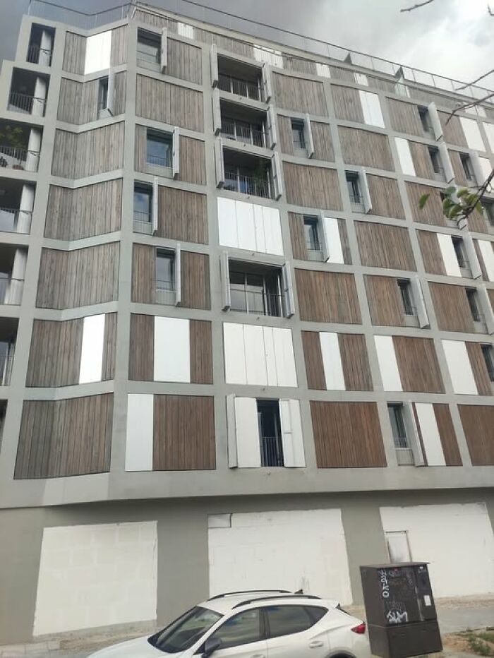 Modern ugly building with unesthetic facade panels and minimal windows, exemplifying depressing architecture trends.