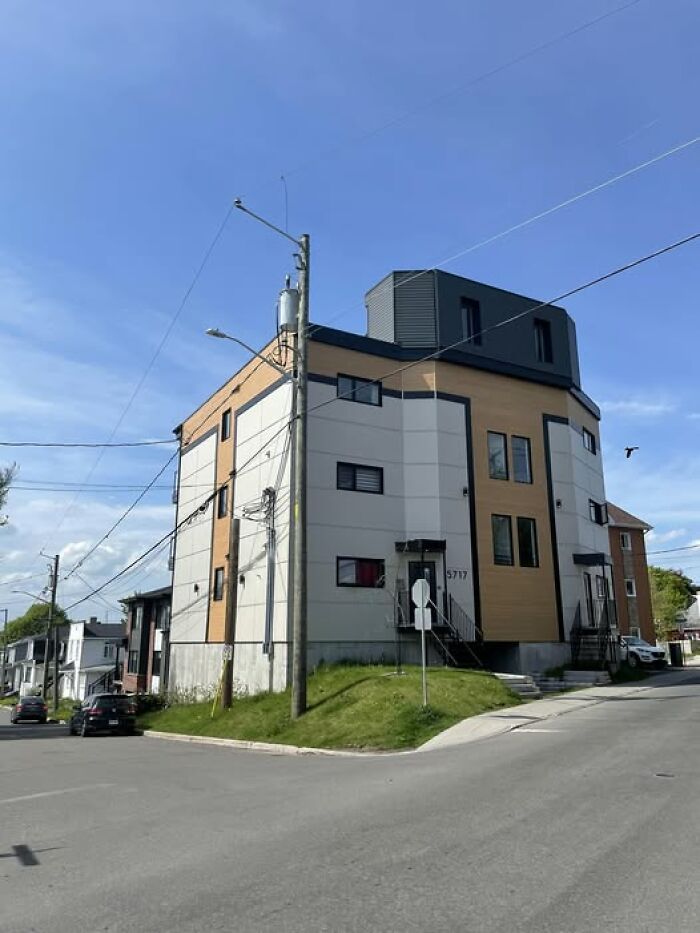 Modern architecture building with mismatched panels and windows on a street corner, showcasing unesthetic design features.