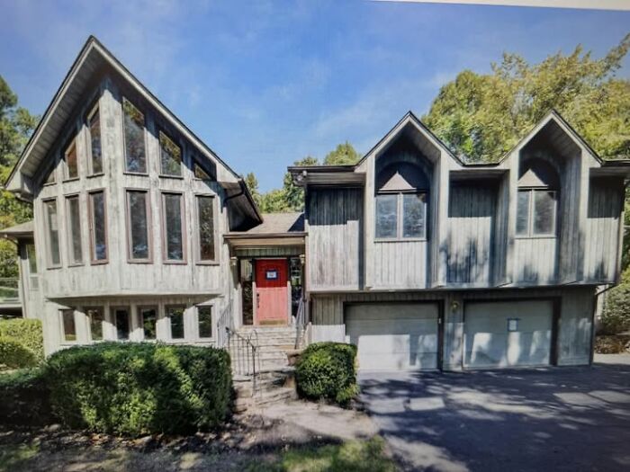 Wooden residential building with large windows and unusual roof design, showcasing ugly and unesthetic modern architecture.