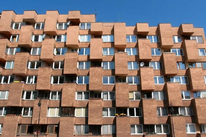 Chunky unesthetic building facade with repetitive block shapes and small windows showing ugly modern architecture design.