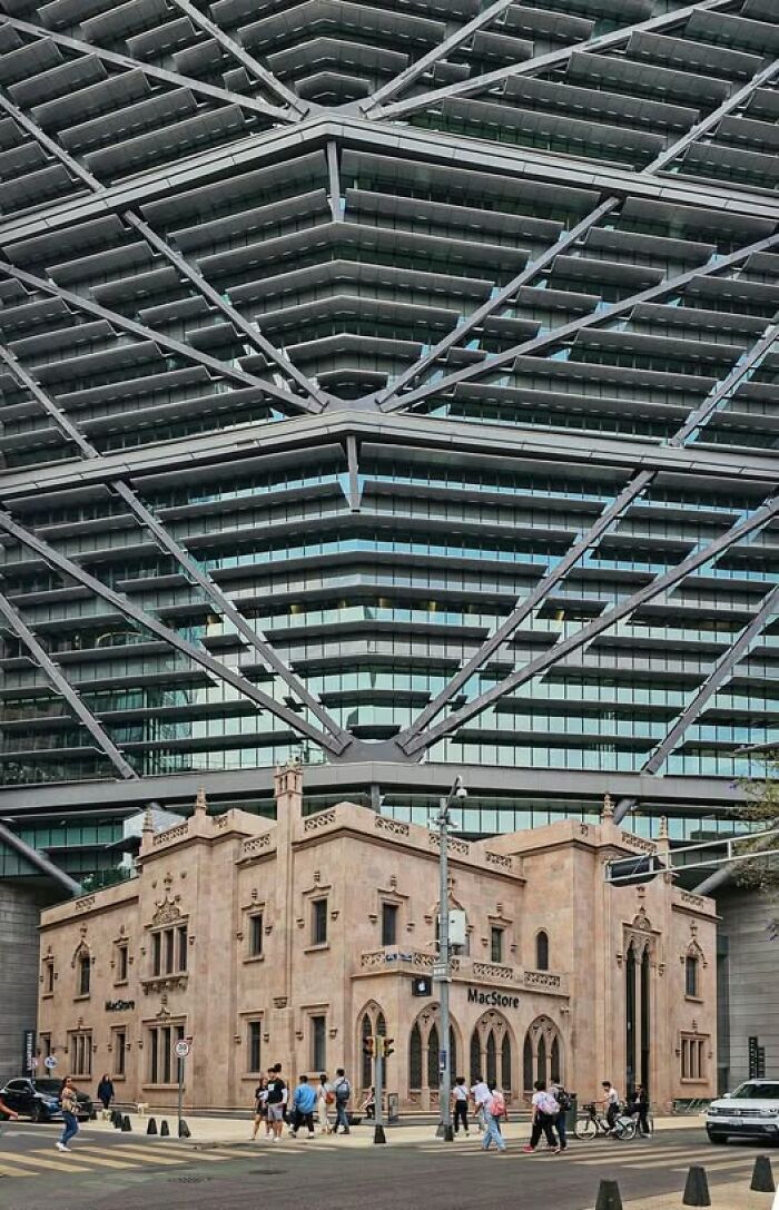 Historic building awkwardly surrounded by modern architecture with ugly unesthetic features overshadowing the design.