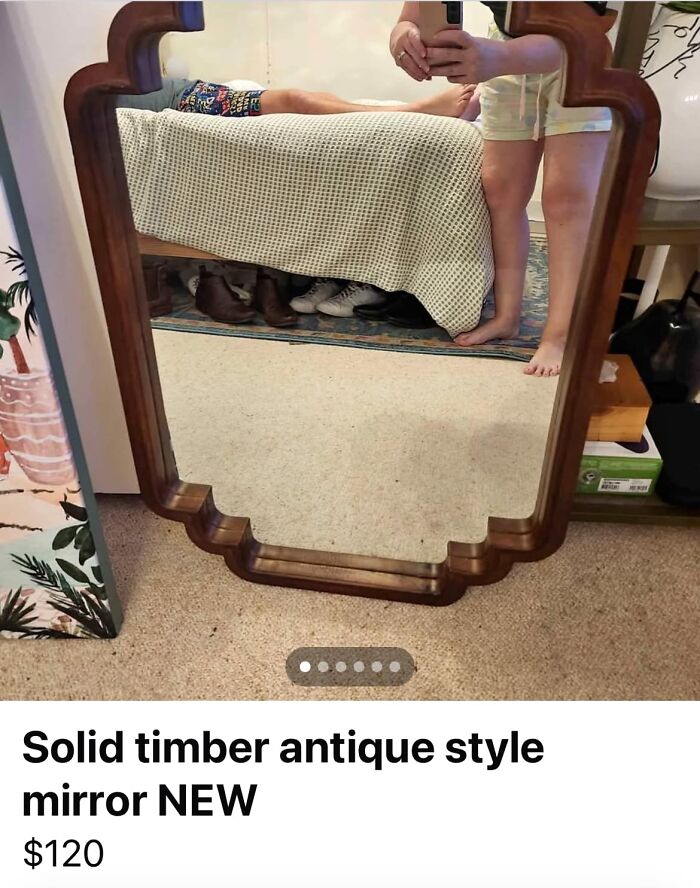 Antique style solid timber mirror with an unusual reflection showing a person and a bed on FB Marketplace post.