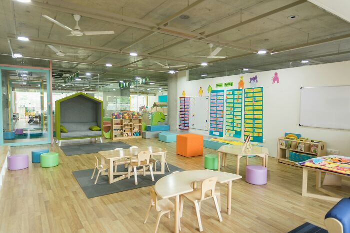 Bright and colorful children's classroom showcasing organized play areas and learning materials, with workers share unprofessional things done implications.