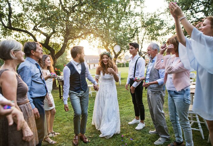 Bride and groom walking through guests outdoors at a wedding ceremony, capturing uniquely awkward wedding moments.