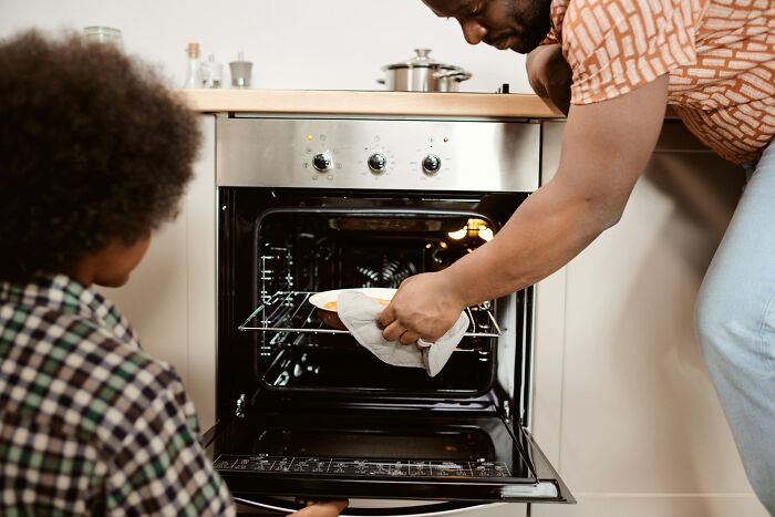 Home cook using an oven with care, focusing on kitchen safety and avoiding common mistakes in cooking techniques.