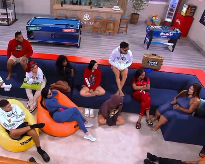 Group of people seated in a casual living room setting, discussing events related to Drake&rsquo;s party revelations.