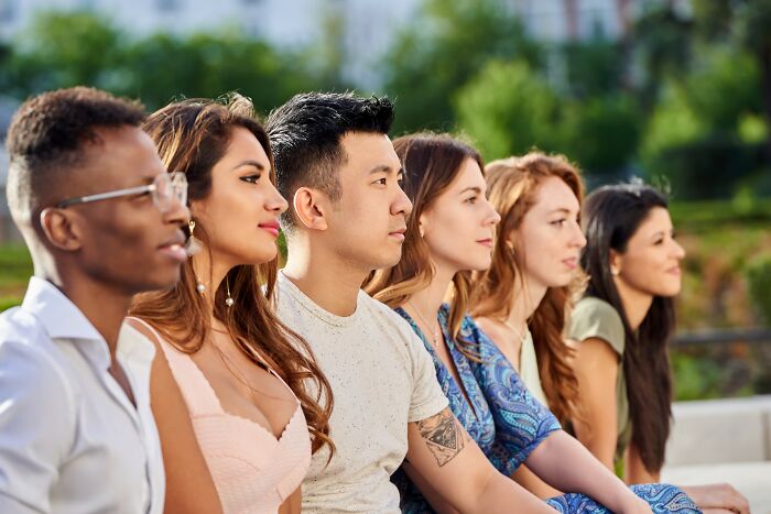 A diverse group of people sitting thoughtfully outdoors, symbolizing deep reflection after internet rabbit holes.
