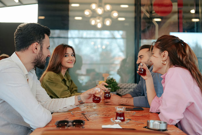 Four people enjoying tea together at a café, sharing moments based on their gut instinct and personal connection.