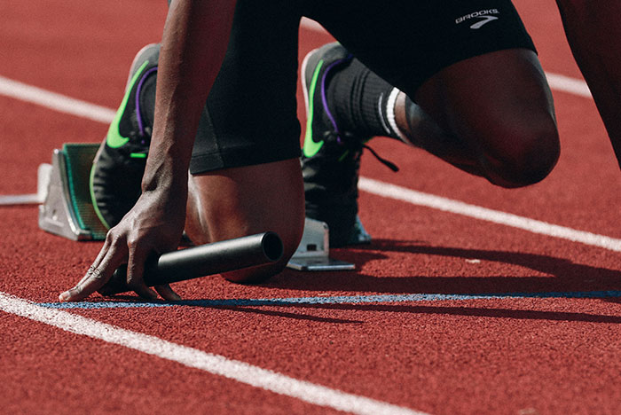 Athlete at starting blocks gripping a relay baton, symbolizing moments their gut instinct was completely correct.