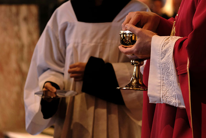 Two people in ceremonial robes holding a chalice and plate, illustrating moments their gut instinct was correct.