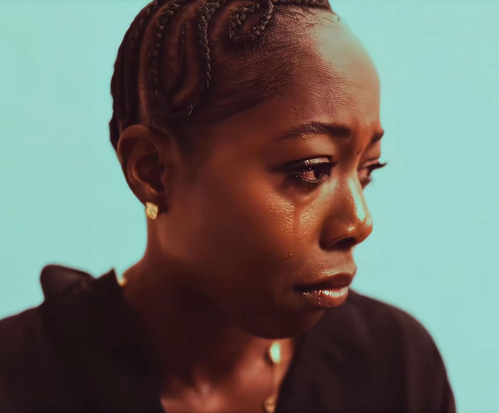 Close-up of a tearful woman, conveying emotion related to trans woman confronted in gym locker room situation.