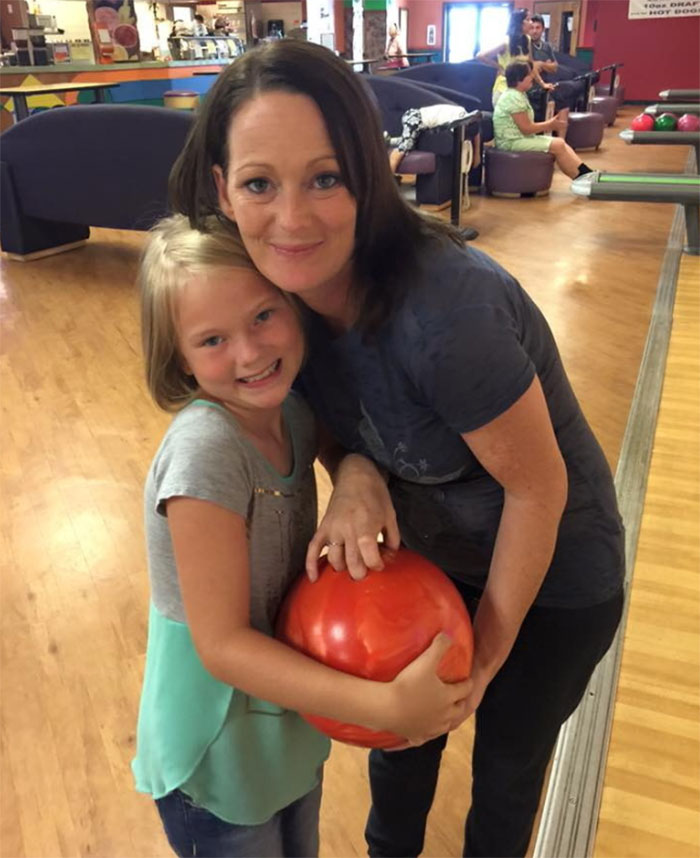 Mother and daughter smiling together at bowling alley, related to stepbrother obsessed with teen slain on cruise story.
