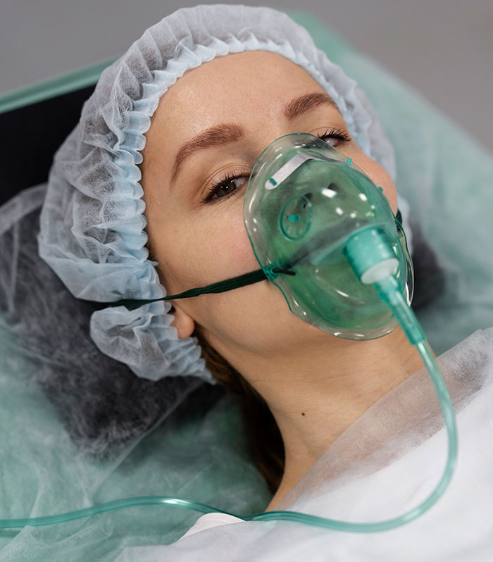 Patient lying in hospital bed wearing oxygen mask and surgical cap, illustrating mysteries about the human body science unexplained