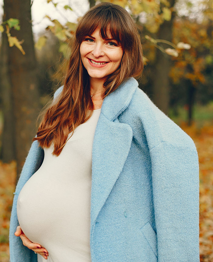 Pregnant woman smiling outdoors, illustrating mysteries about the human body that science still hasn't explained.