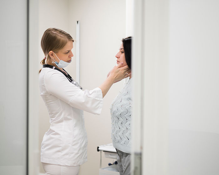 Doctor examining patient's neck in a clinical setting, highlighting mysteries about the human body and science exploration.