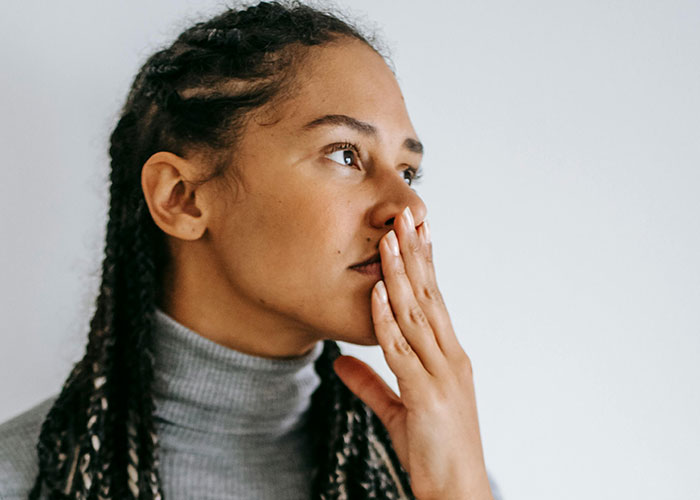 Woman with braided hair in a gray turtleneck looks thoughtful and concerned, reflecting on a supportive but deceitful husband. Woman with braided hair in a gray turtleneck looks thoughtful and concerned, reflecting on a supportive but deceitful husband.