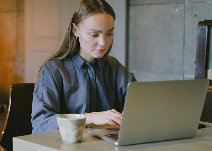 Woman looking concerned while using laptop, illustrating a woman finding out about her husband's unkind behavior. Woman looking concerned while using laptop, illustrating a woman finding out about her husband's unkind behavior.