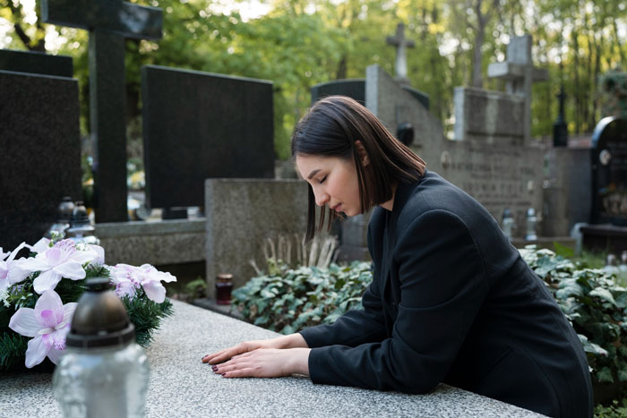 Woman dressed in black at a gravesite, reflecting on obsession mistaken for pregnancy as a life-threatening condition sign.