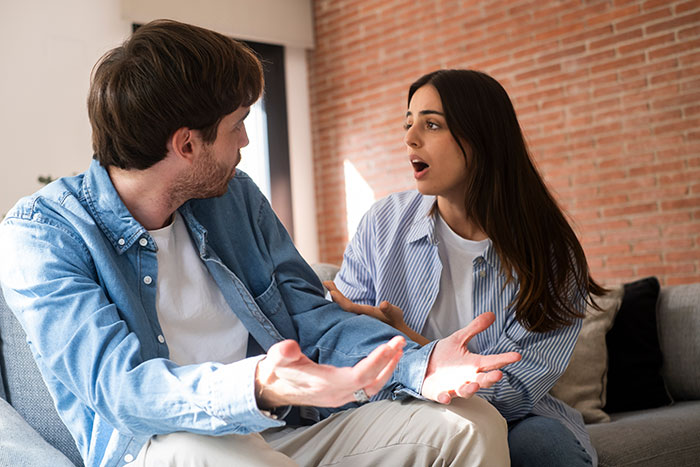 Couple having an emotional conversation on a couch, showing reactions linked to groom’s vows and mixed feelings. Couple having an emotional conversation on a couch, showing reactions linked to groom’s vows and mixed feelings.