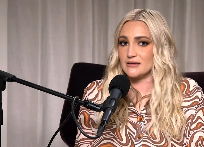 Woman with wavy blonde hair speaking into a microphone, sharing candid James Franco smells stories in a casual setting.