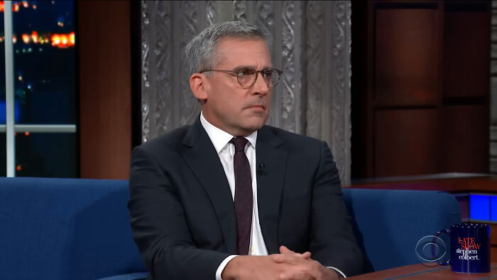 Steve Carell on the Late Show with Stephen Colbert, wearing a suit and glasses, engaged in a serious conversation about James Franco smells.