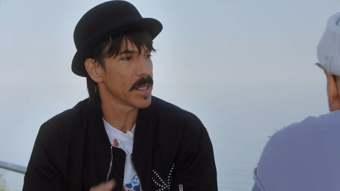 Man wearing black hat and jacket in an outdoor conversation, related to James Franco smells stories about meeting him.