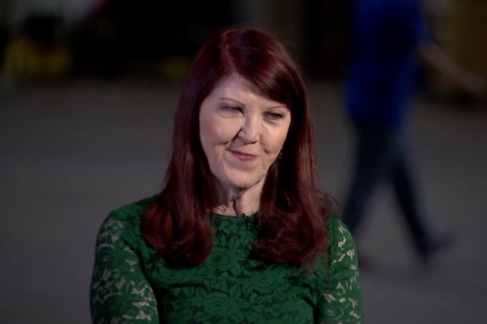 Woman with red hair in a green lace top sharing a story about meeting James Franco in a casual indoor setting.