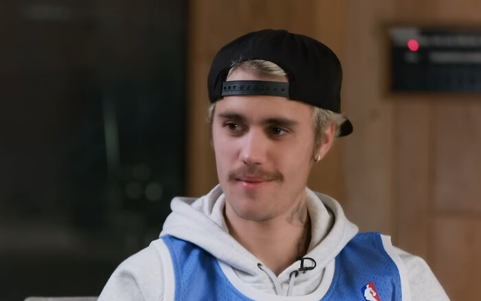 Young man wearing a black cap and blue jersey in a casual indoor setting, related to James Franco smells discussion.