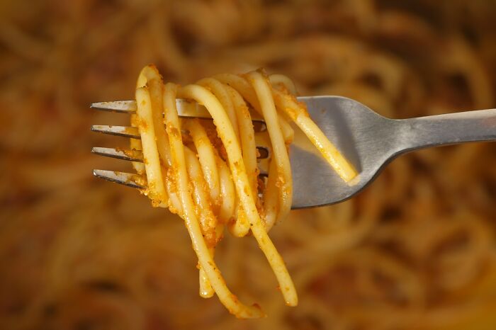 Close-up of spaghetti twirled on a fork, illustrating a simple moment connected to the butterfly effect in real life.