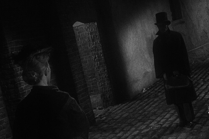 Silhouetted figure in Victorian-era clothing on cobblestone street, evoking Jack the Ripper&rsquo;s real identity mystery.