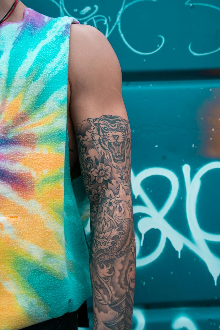 Close-up of a man&rsquo;s arm with detailed tattoo art, symbolizing tattoo regret and emotional struggles with depression.