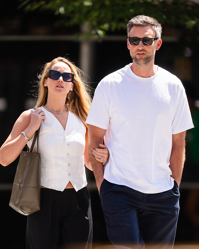 Jennifer Lawrence walking outdoors with a man, both wearing sunglasses, highlighting male co-stars and punishment claims.