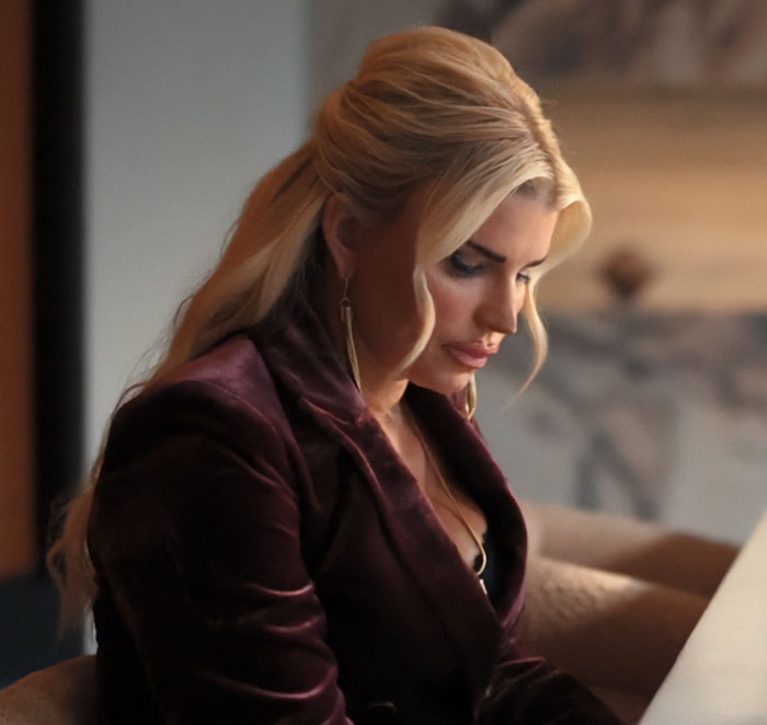 Jessica Simpson sitting indoors with styled blonde hair, showcasing her appearance after botched plastic surgery for acting role.