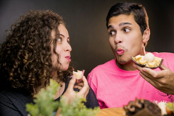 Couple sharing dessert at a table, illustrating surprising habits and secrets people discover about their partner after moving in.