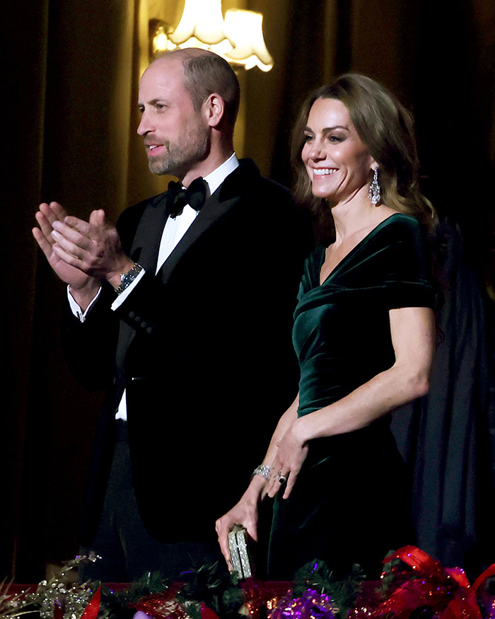 Kate Middleton with healthy-looking hair wearing an emerald dress and statement earrings at a formal event with Prince William.