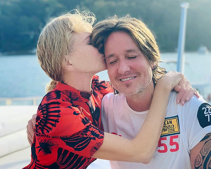Nicole Kidman affectionately kissing Keith Urban outdoors, with Tom Cruise reportedly breaking silence on their split karma.