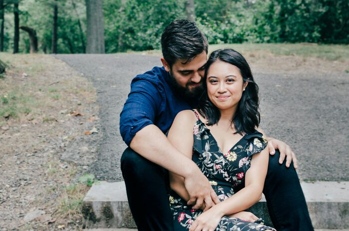 Couple sitting outdoors on steps in a park, illustrating family dynamics and golden child stories in long-term relationships.