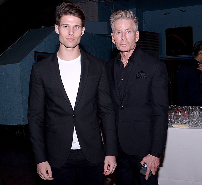 Calvin Klein, 83, and his 36-year-old boyfriend dressed in black suits at a formal indoor event.